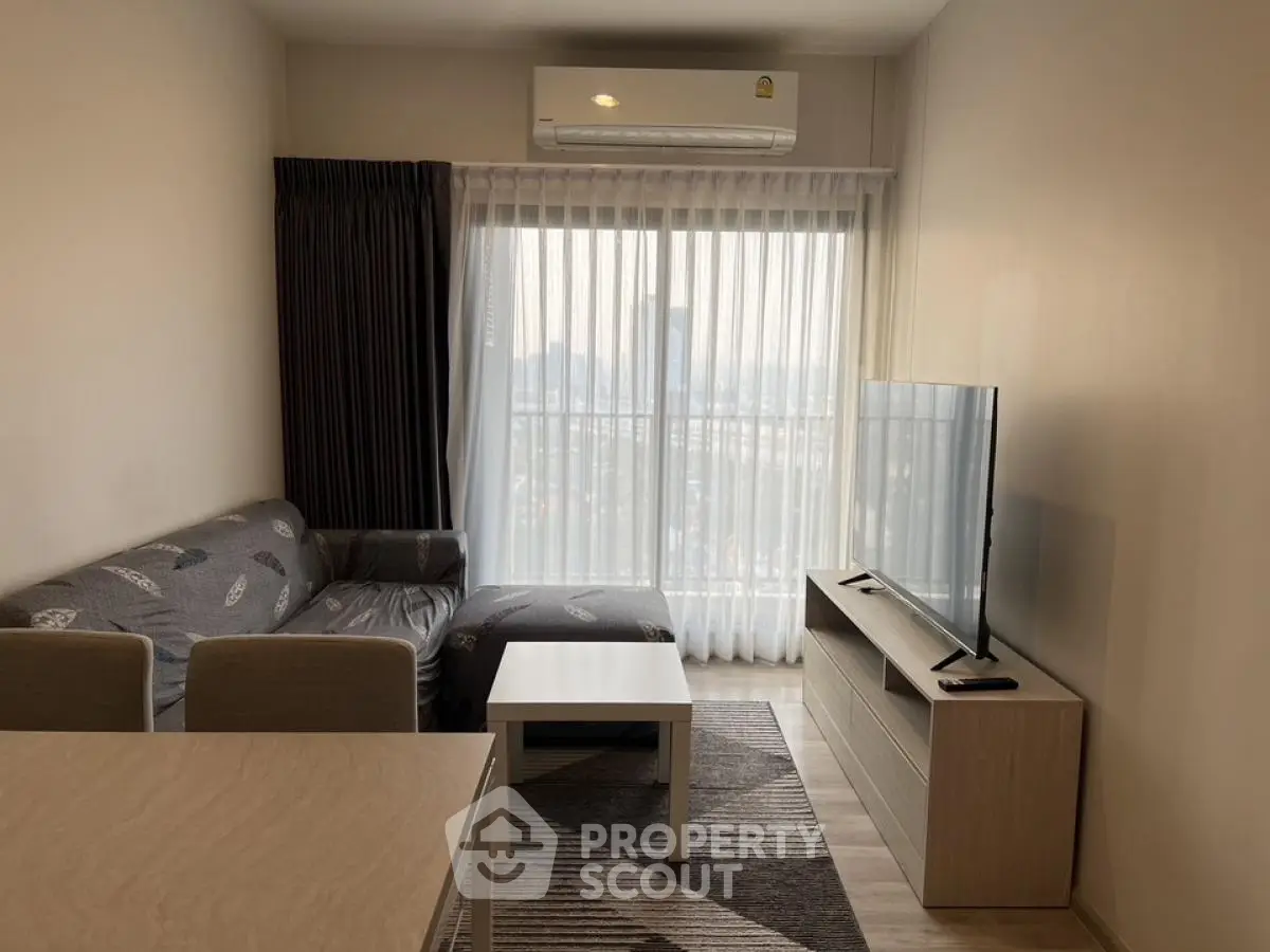 Modern living room with cozy sofa, flat-screen TV, and large window with city view.