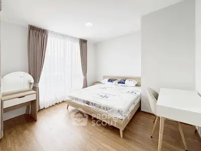 Bright and airy bedroom with modern furnishings and large window for natural light.