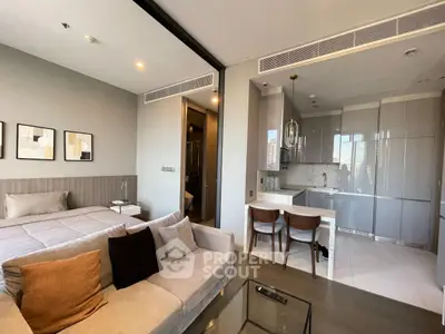 Modern studio apartment with open kitchen and cozy living area, featuring sleek design and natural light.