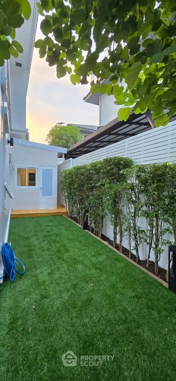 Charming garden area with lush greenery and modern design, perfect for relaxation and outdoor activities.