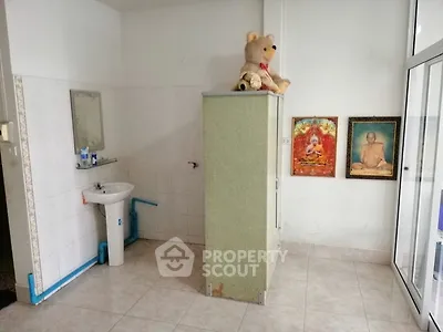 Simple bathroom with sink, mirror, and storage cabinet, featuring tiled floor and wall decor.