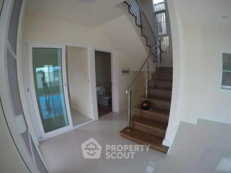 Modern interior with staircase and sliding glass door leading to a pool area.