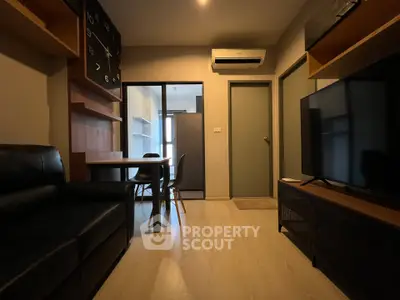 Modern living room with sleek furniture and large TV, featuring a stylish open layout and contemporary design.