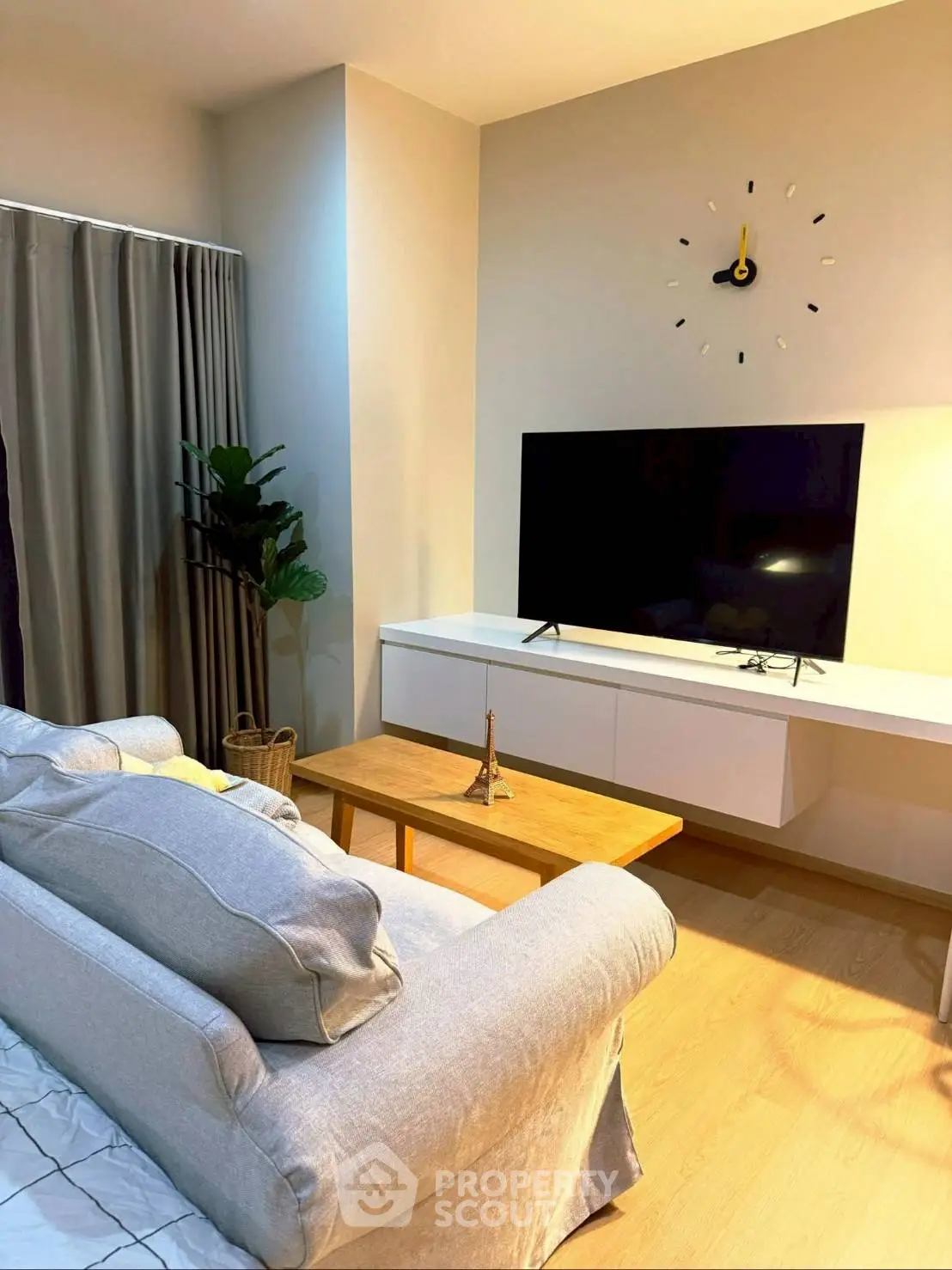 Modern living room with stylish decor, featuring a sleek TV setup and cozy seating area.