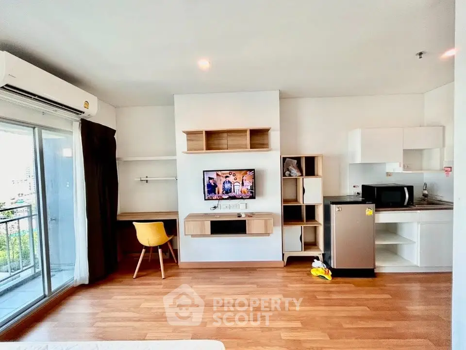 Modern studio apartment with open layout, featuring a compact kitchen, cozy living area, and balcony access.