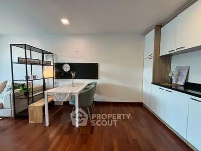 Modern open-plan living room and kitchen with stylish decor and wooden flooring.