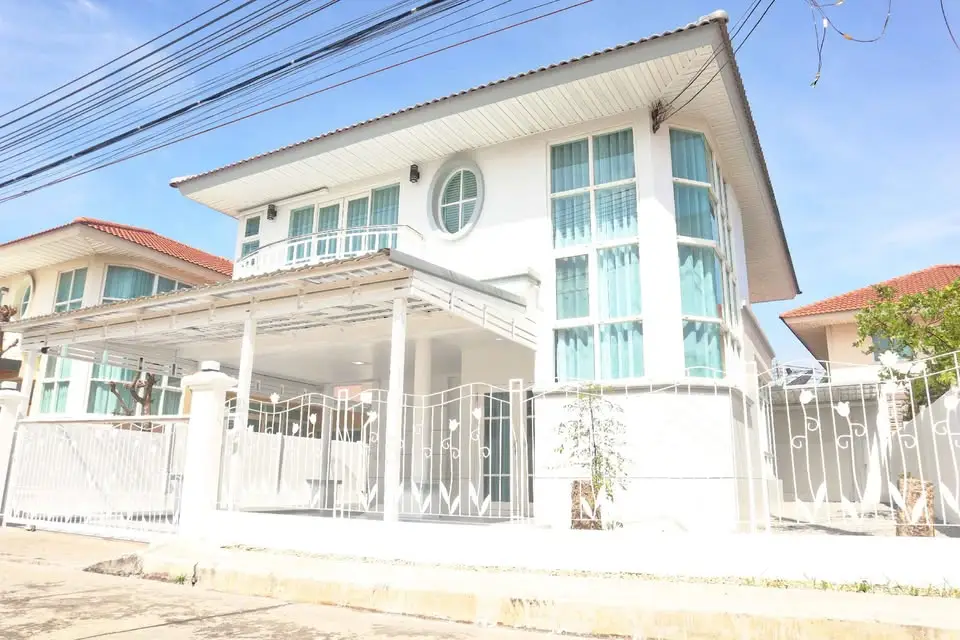 Stunning modern two-story house with large windows and a spacious driveway in a serene neighborhood.