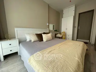 Spacious bedroom with modern decor and ample storage in a stylish apartment.