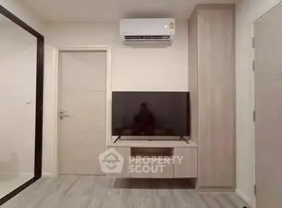 Modern living room with sleek TV setup and air conditioning unit