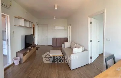 Modern living room with sleek furniture and wooden flooring, perfect for cozy gatherings.