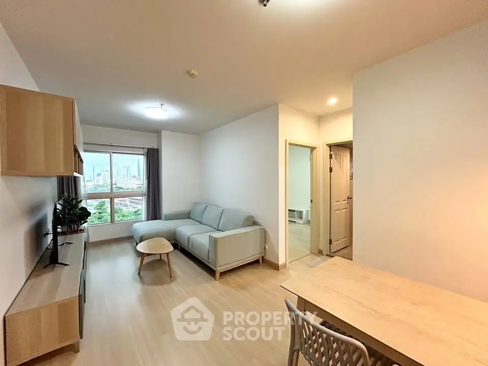 Spacious modern living room with city view, light wood flooring, and stylish furniture.