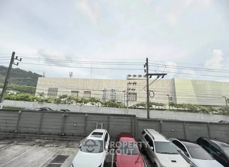 Spacious parking area with modern building backdrop and scenic mountain view.
