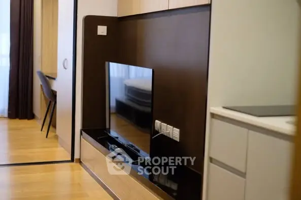 Modern apartment interior with sleek TV setup and wooden flooring
