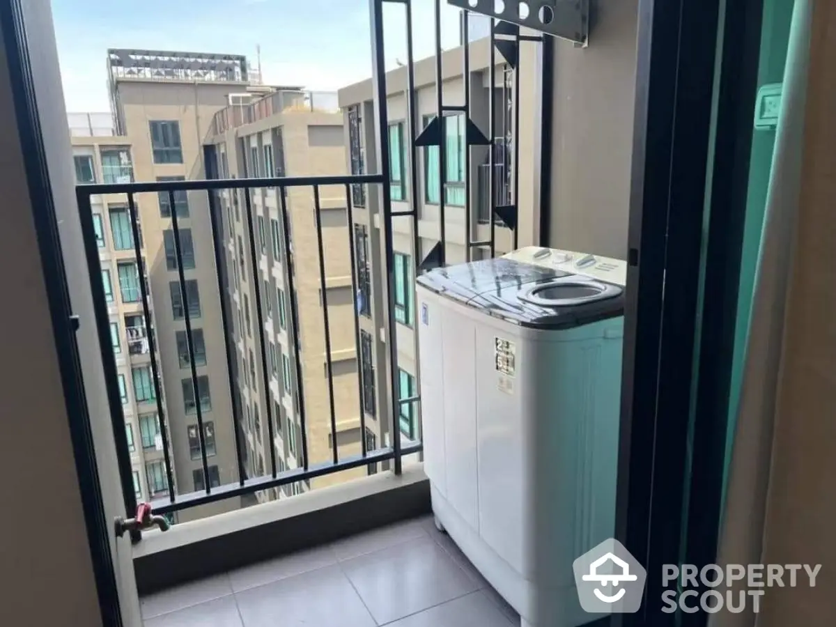 Compact balcony with washing machine and urban view in modern apartment.