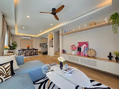 Modern living room with stylish decor and open layout, featuring cozy seating and elegant lighting.