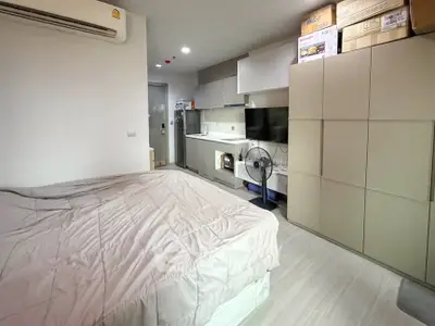 Modern studio apartment with compact kitchen and cozy sleeping area, ideal for urban living.