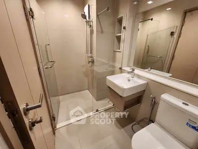 Modern bathroom with glass shower and sleek fixtures in a contemporary apartment.
