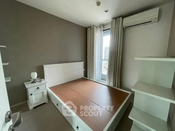 Cozy bedroom with air conditioning and balcony access in modern apartment.