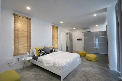 Spacious modern bedroom with stylish decor and ample natural light