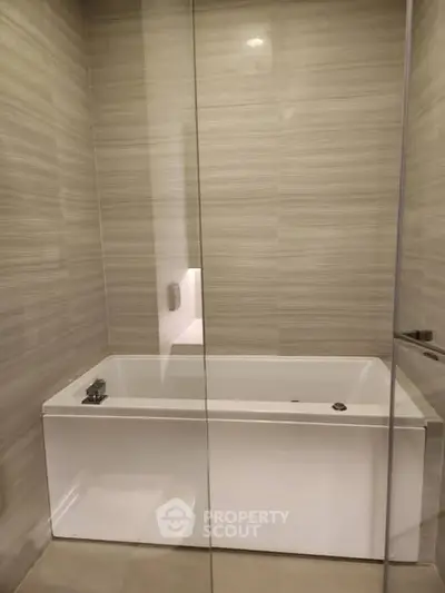 Modern bathroom with sleek bathtub and glass enclosure