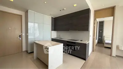 Modern kitchen with sleek cabinetry and island in open layout apartment
