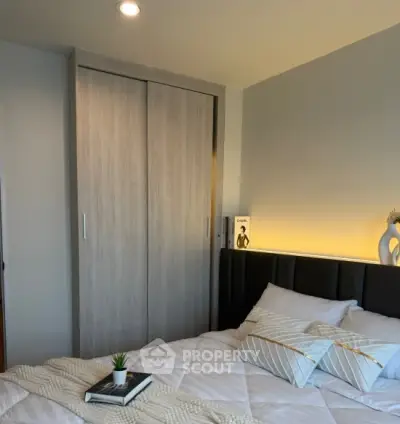 Cozy bedroom with modern decor and soft lighting, featuring a stylish bed and built-in wardrobe.