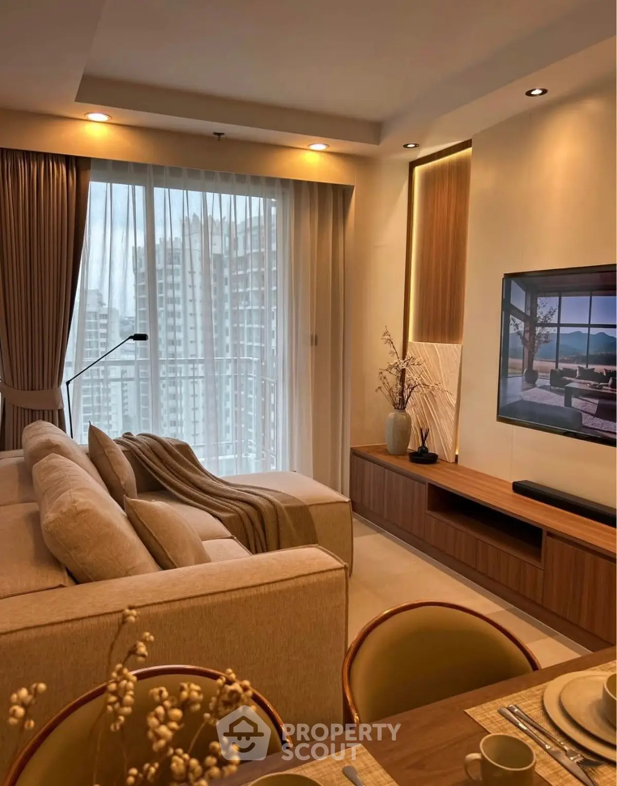 Modern living room with elegant decor and city view through large window.