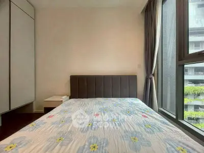 Modern bedroom with large window and floral bedding in a stylish apartment.