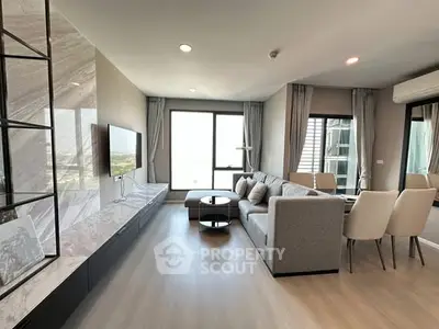 Modern living room with sleek design, large windows, and stylish furniture in a high-rise apartment.