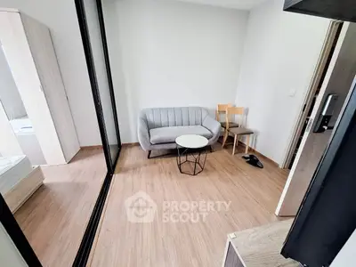 Cozy living room with modern sofa and wooden flooring in a compact apartment.
