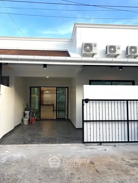 Modern house entrance with sleek design and multiple air conditioning units.