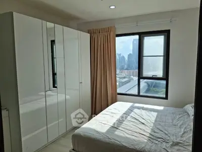 Bright bedroom with large window and city view, featuring a sleek white wardrobe and cozy bed.