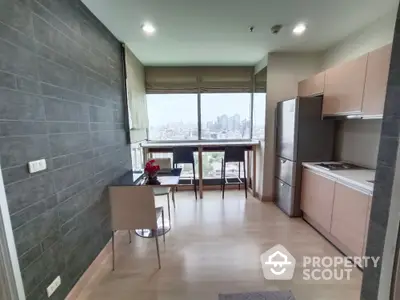 Modern kitchen with city view, sleek cabinetry, and breakfast bar in high-rise apartment.