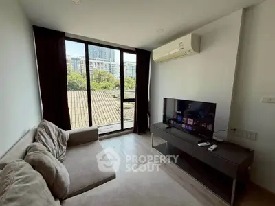 Modern living room with large window and city view, featuring a cozy sofa and flat-screen TV.
