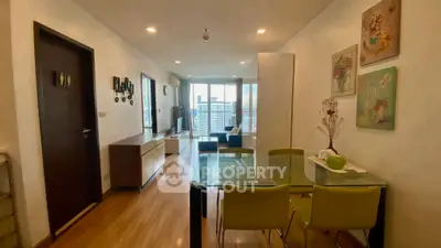 Modern apartment interior with open living and dining area, featuring stylish decor and city view.