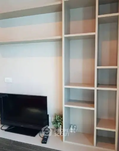 Modern living room with sleek TV unit and open shelving, perfect for stylish urban living.