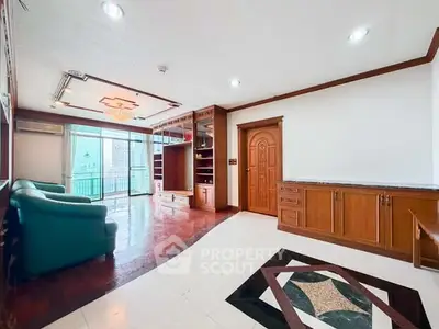 Spacious living room with elegant wooden cabinetry and large windows offering city views.