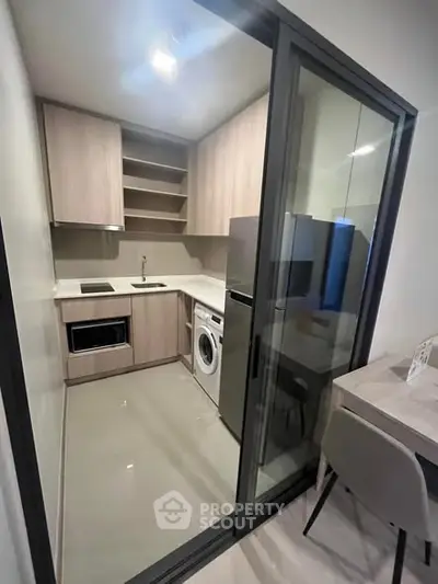 Modern compact kitchen with washing machine and sleek cabinetry