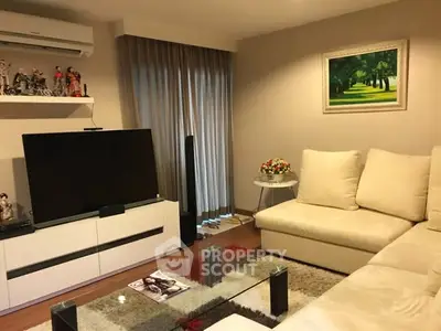 Modern living room with cozy sofa, large TV, and elegant decor in a stylish apartment.