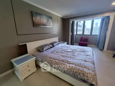Spacious bedroom with modern decor and city view, featuring a comfortable bed and stylish furnishings.