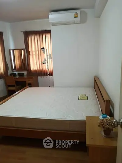 Cozy bedroom with wooden furniture and natural light, perfect for relaxation.