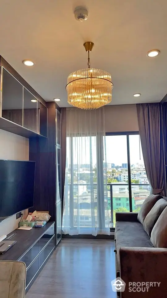 Modern living room with elegant chandelier and city view balcony