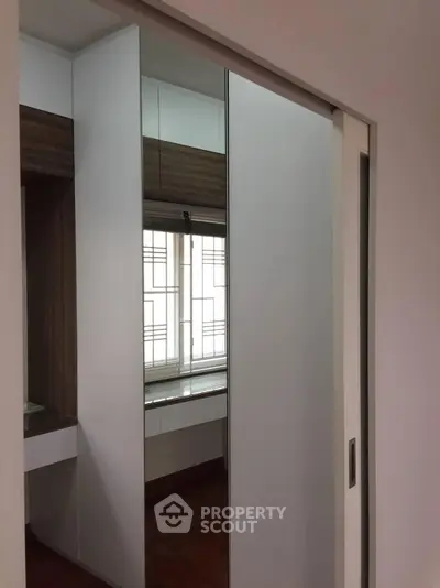 Modern closet with sliding mirror doors in a stylish bedroom setting.