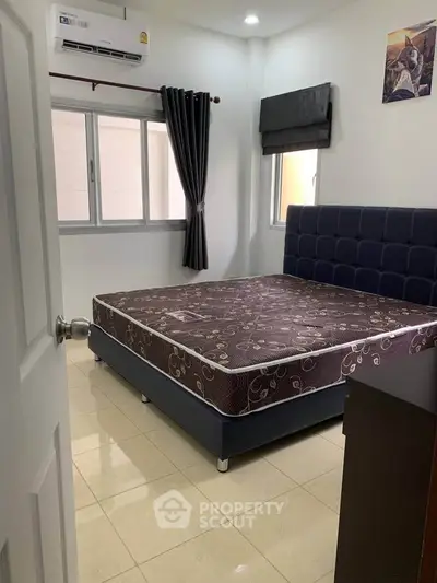 Cozy bedroom with modern bed and air conditioning, perfect for relaxation.