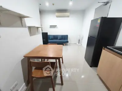 Modern open-plan living room with dining area and sleek kitchen appliances