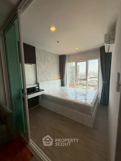 Modern bedroom with city view and large windows in a high-rise apartment