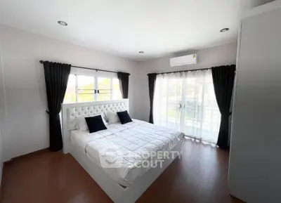 Spacious bedroom with elegant decor and natural light, featuring a comfortable bed and modern design.