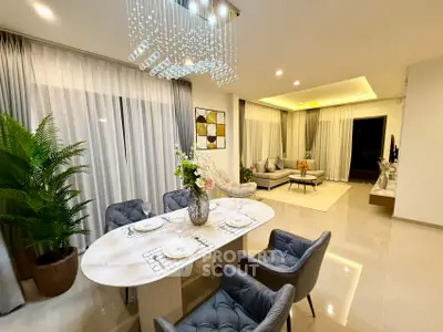 Luxurious open-plan living and dining area with elegant decor and modern lighting.