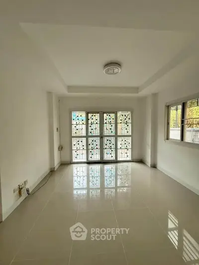 Bright and spacious living room with large windows and modern lighting in a contemporary home.