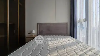 Modern bedroom with large window and elegant furnishings in a high-rise apartment.